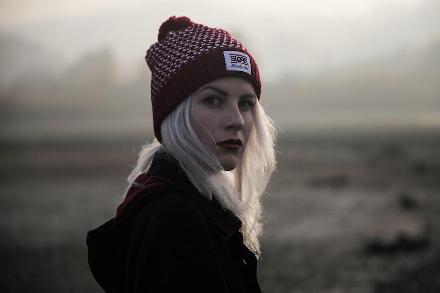 Femme blonde posant avec un bonnet rouge