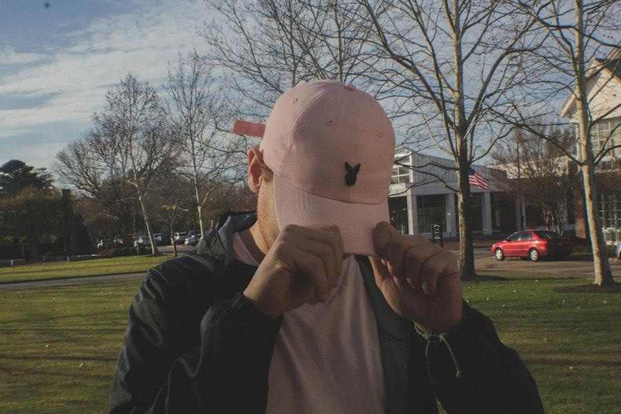 man holding a pink rabbit trucker hat