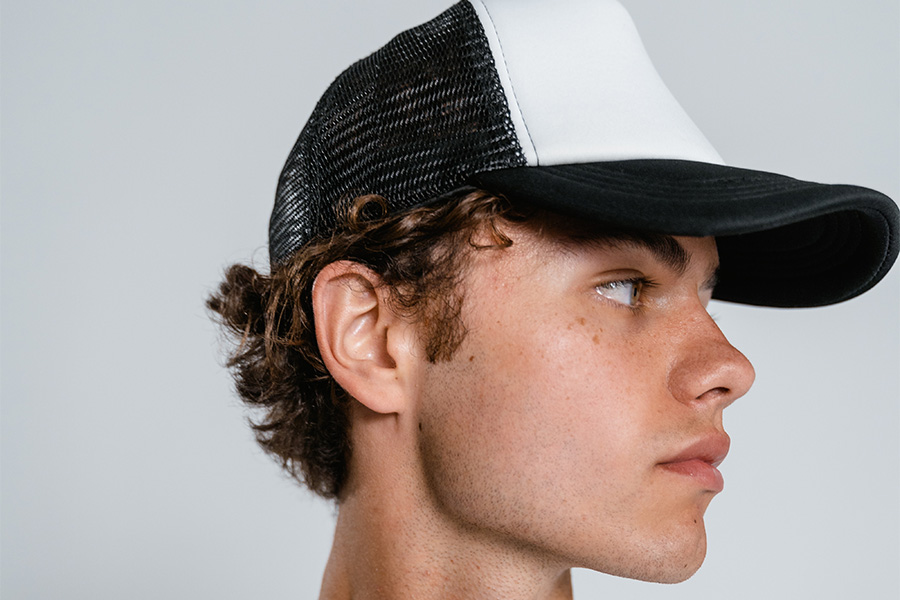 Man looking sideways in a mesh trucker hat