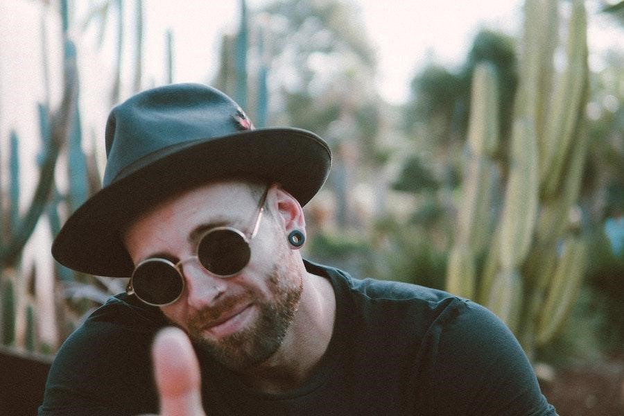 Man posing with a black fedora hat