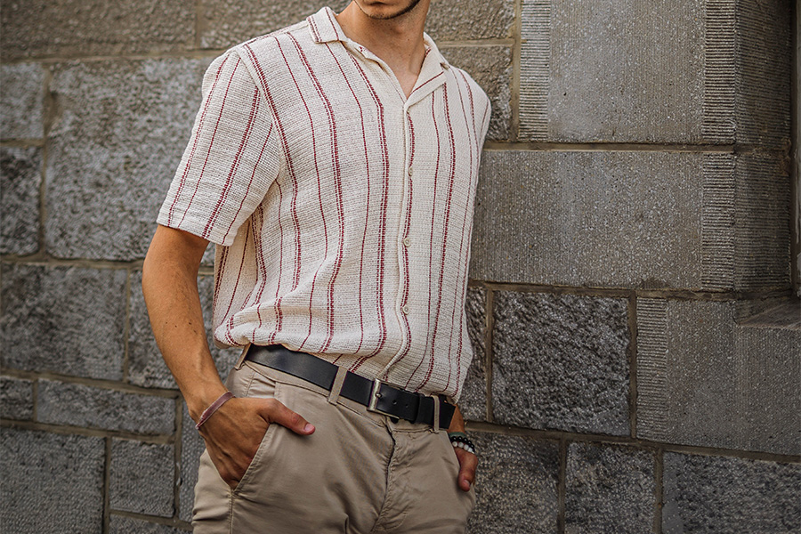 man resting on wall in an oversized mundane shirt