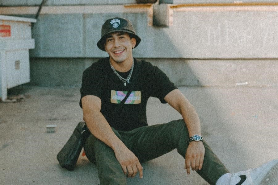 Man wearing a black bucket hat sitting on the floor