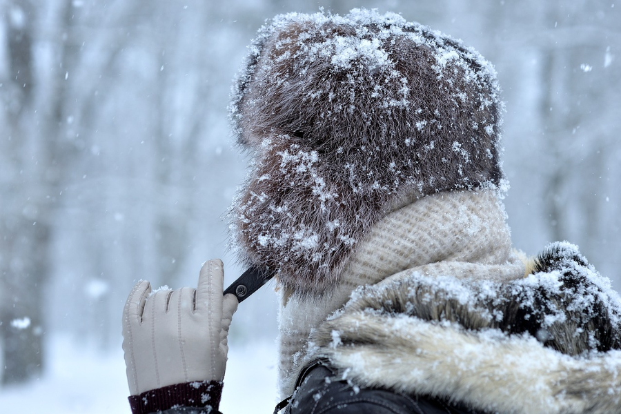 Man wearing a furry hat in the snow