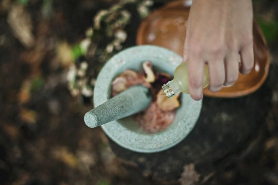 Person pouring liquid into mortar and pestle