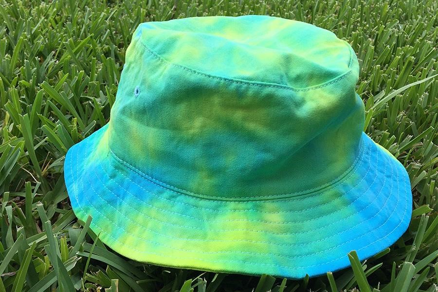 Topi ember tie-dye diletakkan di atas rumput