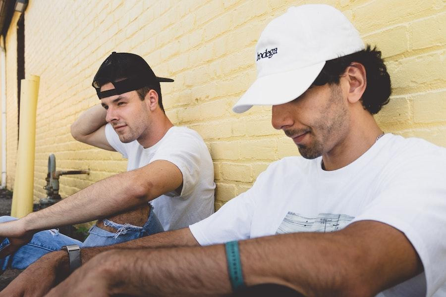 two men wearing snapback trucker hats