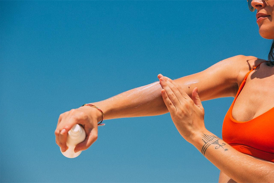 woman applying sunscreen to her arm