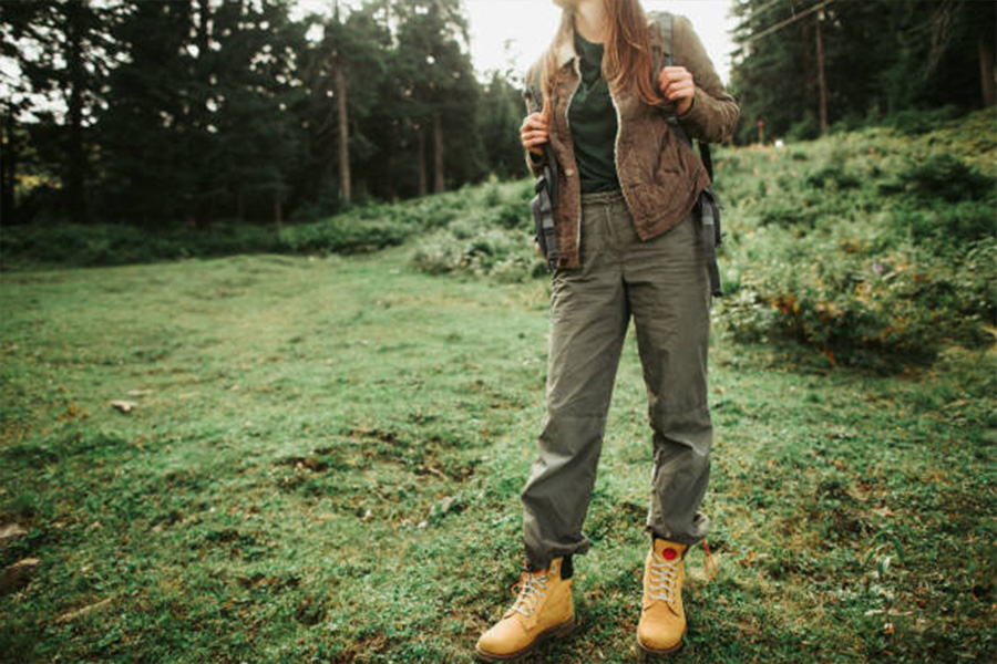 Woman hiking in adventure trousers and large boots in spring