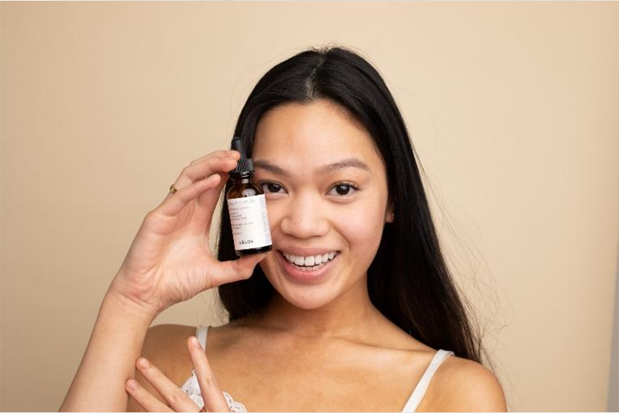 Woman holding bottle of face serum