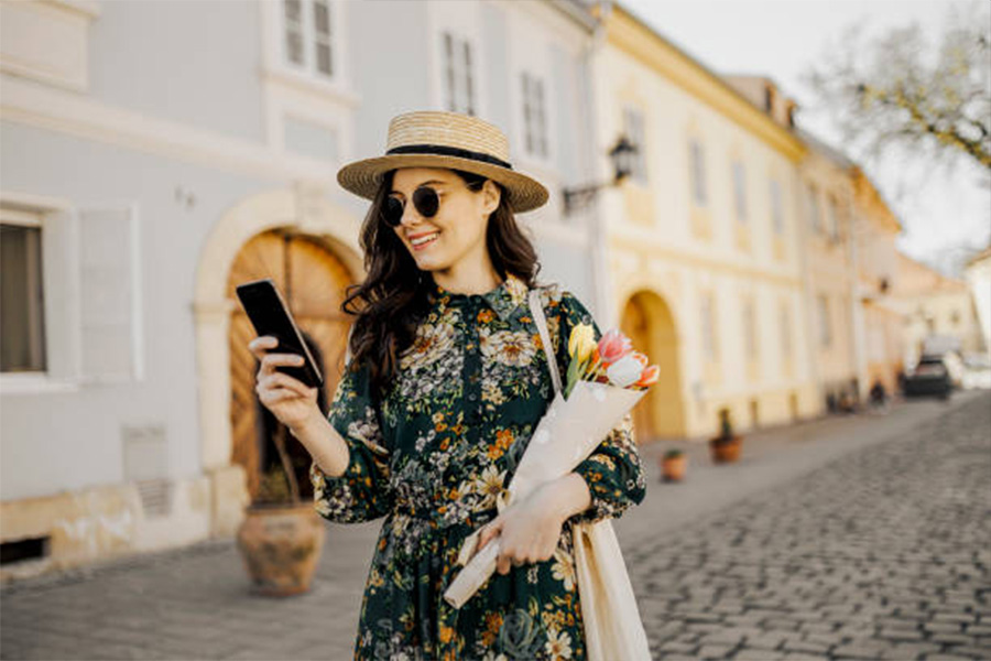 Woman in a straw spring hat walking on cobbled street