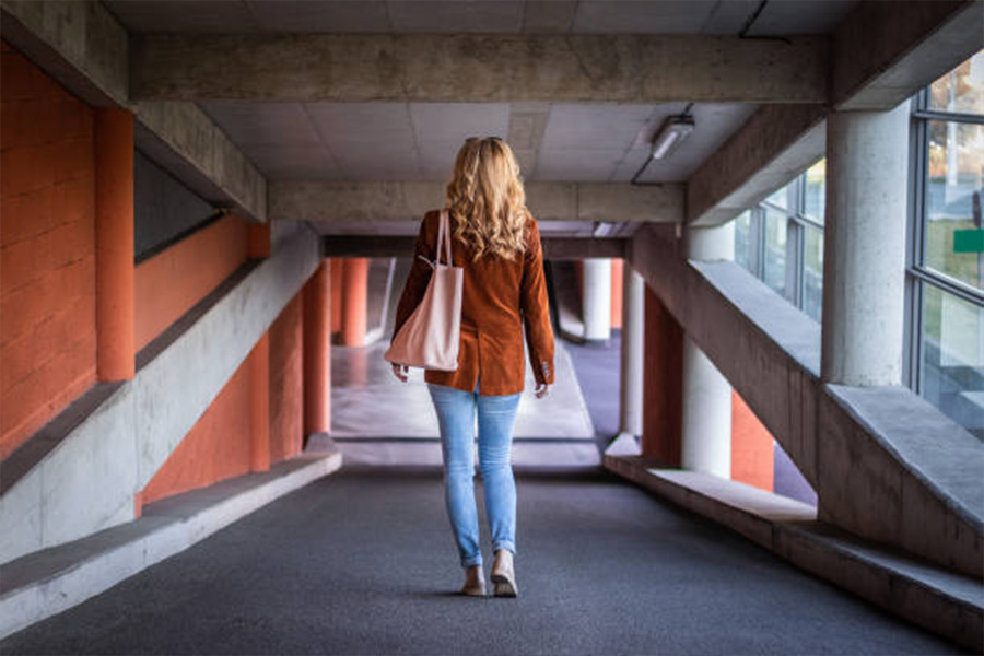 Frau in Jeans und brauner Cordjacke im Parkhaus