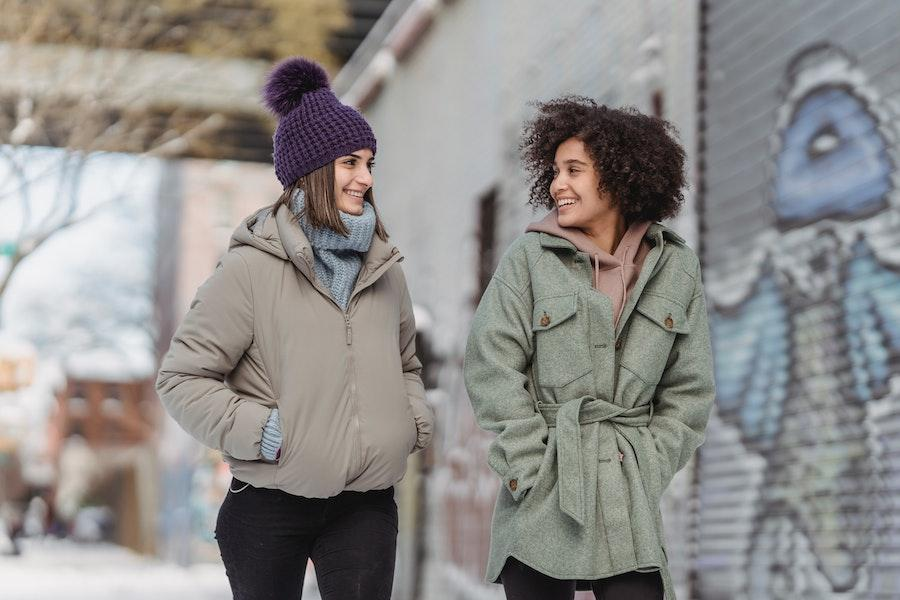 ポンポンビーニーを揺らしながら別の女性と話す女性