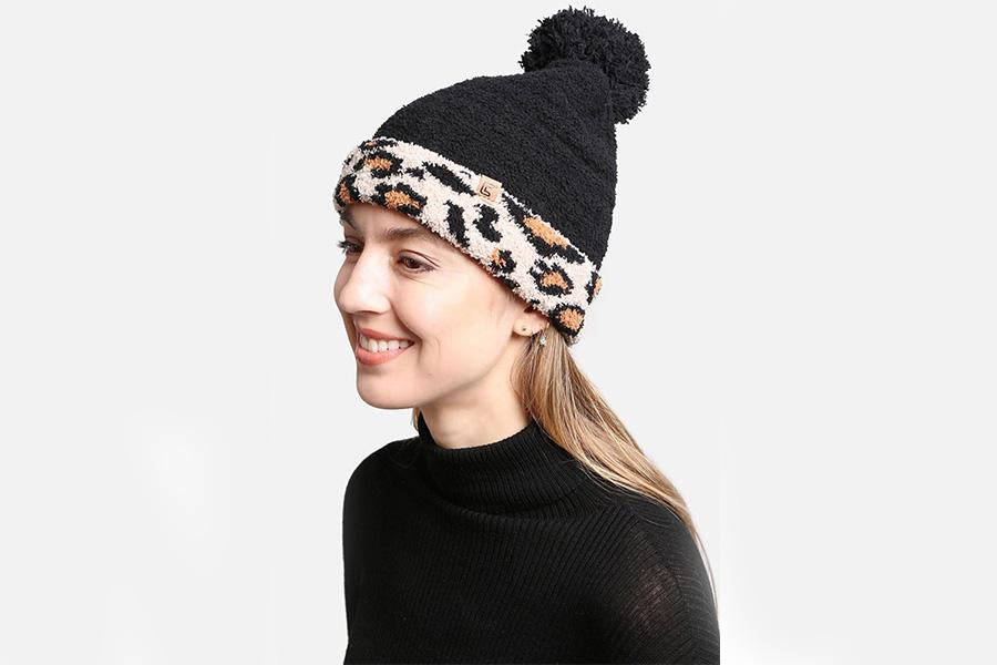 Wanita tersenyum dengan topi bobble bermotif macan tutul