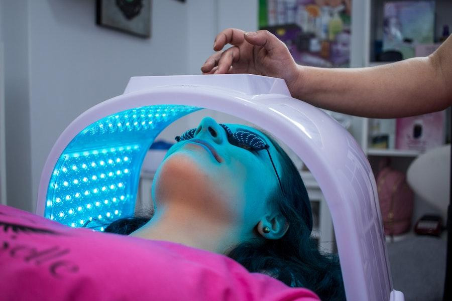 donna che utilizza la tecnologia per la cura della pelle sul viso