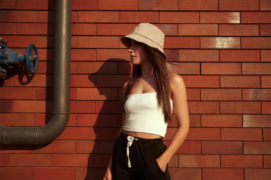 Woman wearing a beige bucket hat with crop top