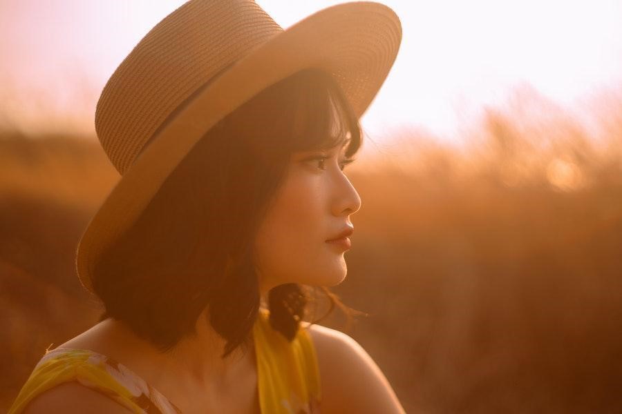 Woman wearing a straw hat sitting in a wheat field