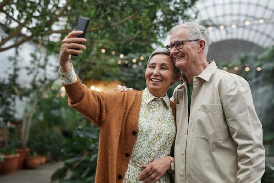 Um casal sênior clicando em uma selfie em um smartphone