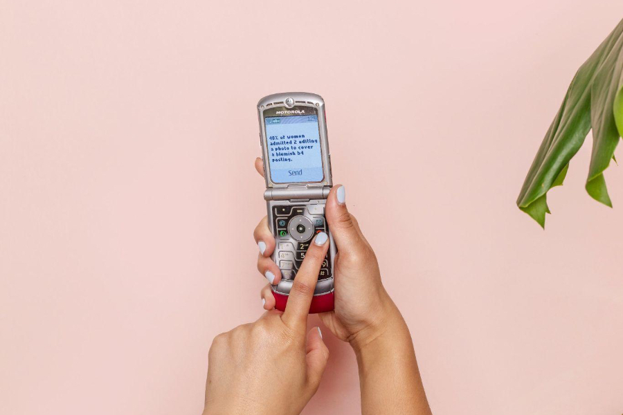 Uma mulher operando um telefone flip prateado