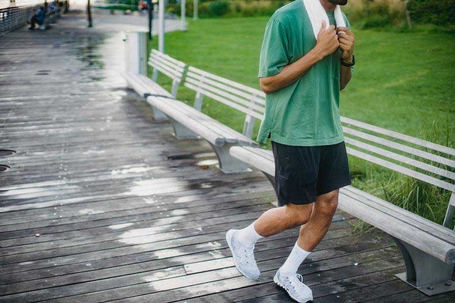 Man wearing a green loose-fit shirt andblack shorts