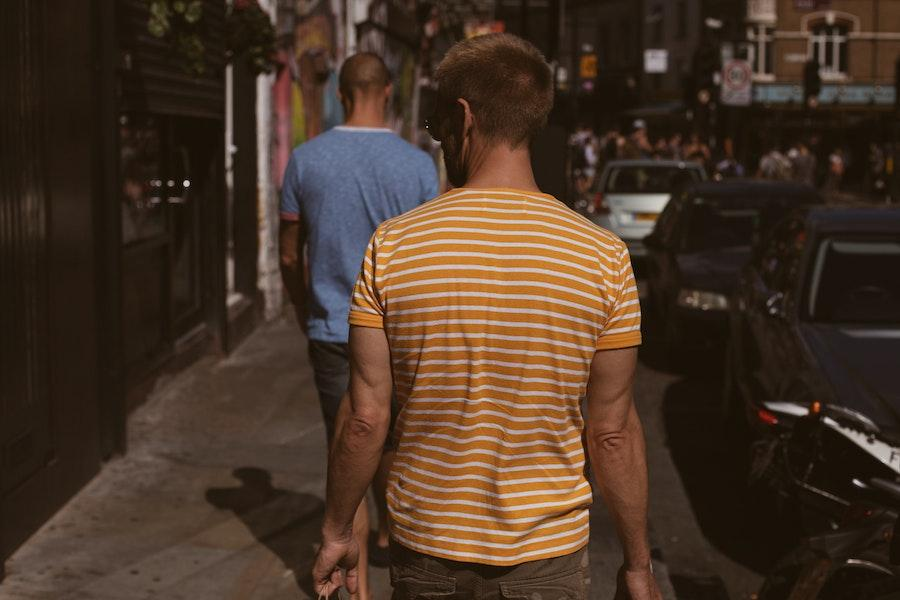 Hombre vestido con camiseta náutica de rayas naranjas y blancas