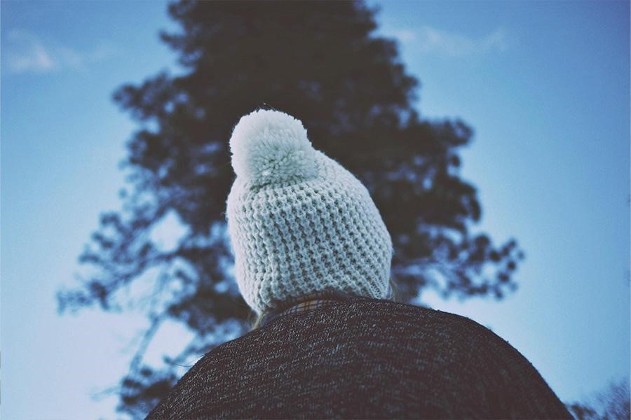 Personne portant un bonnet tricoté avec un pompon