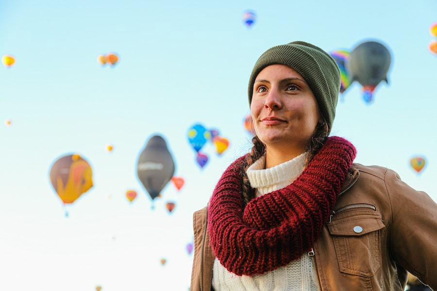 Pretty woman wearing a green beanie and brown jacket