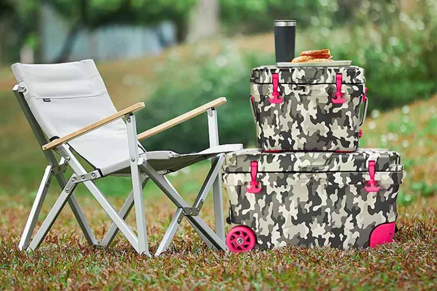 Zwei unterschiedlich große Camouflage-Kühlboxen mit rosa Rädern