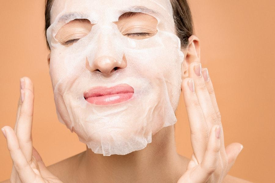 Woman applying a transparent face mask