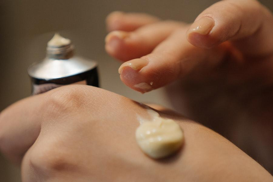 Woman applying fermented cream on hands