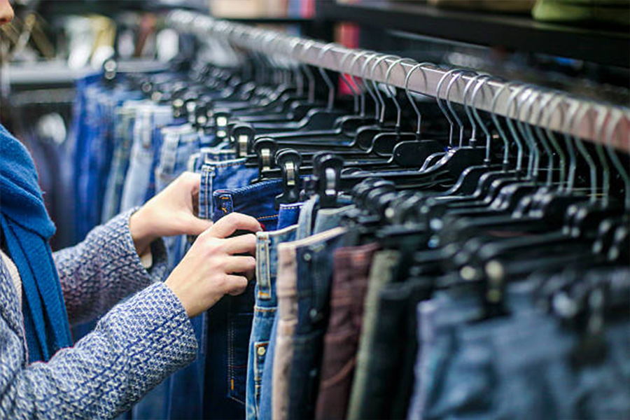 Woman picking out jeans from a rack in a store