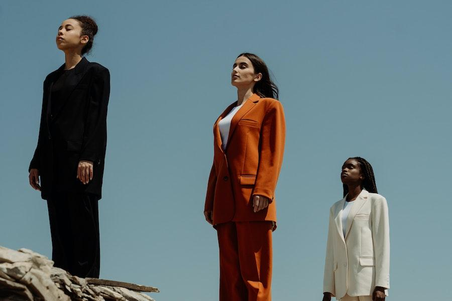 Women standing in a line while rocking colorful tailoring