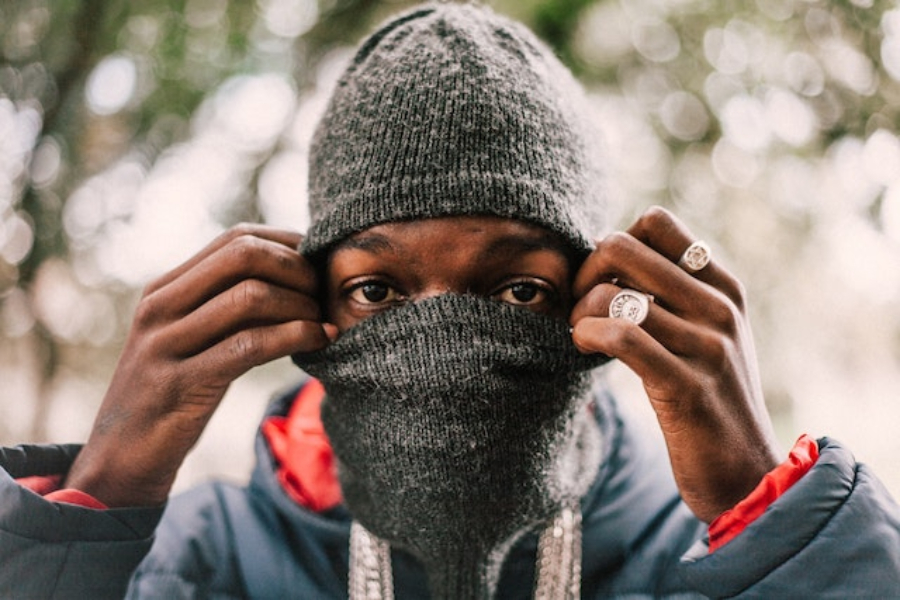 A man wearing a gray knit balaclava hat