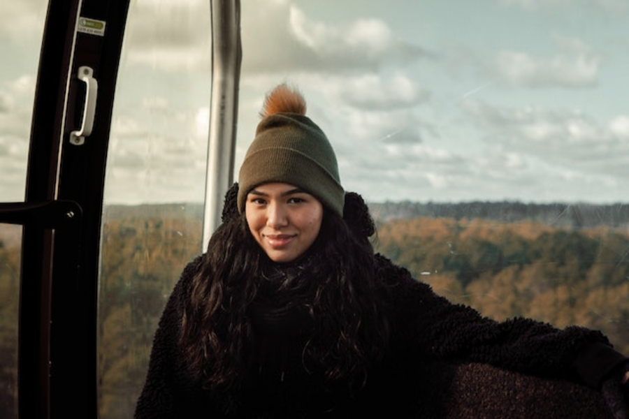 A Woman Wearing A Brown Pom Pom Beanie Hat