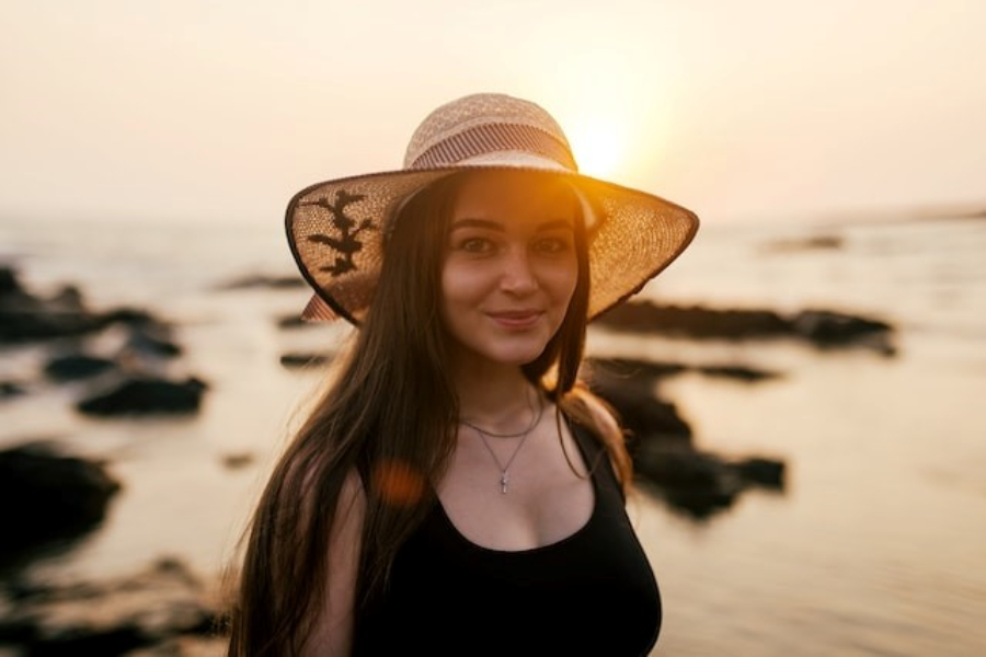 A woman wearing an embroidered straw sun hat