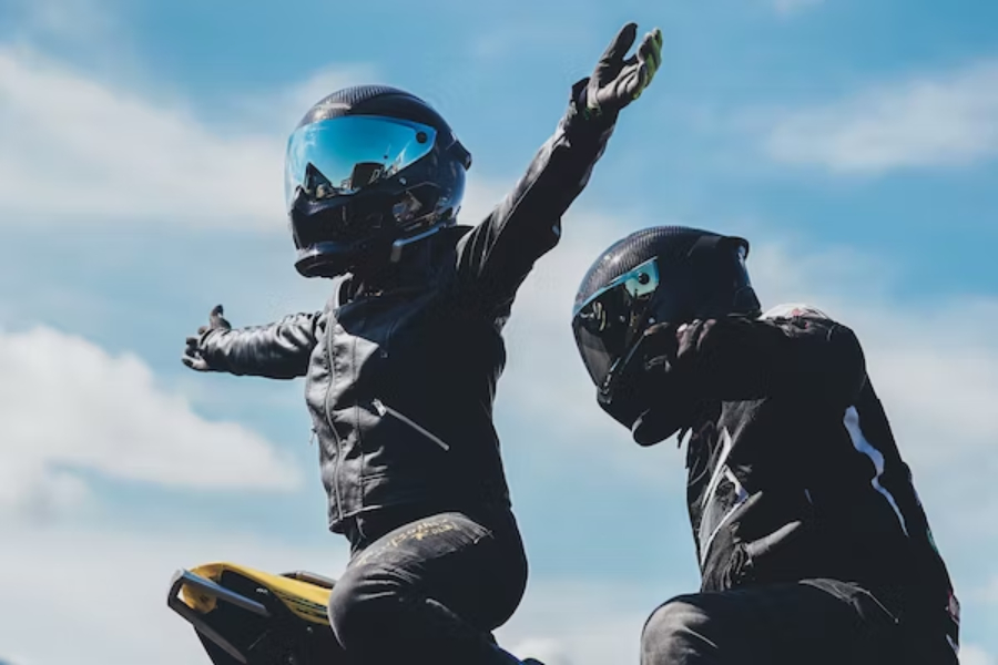 Two bikers wearing black waxed biker jackets outside